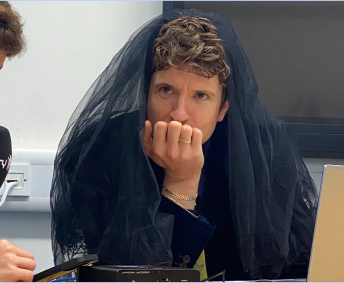Greg James sitting in a mourning viel