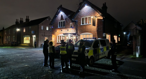 Police standing outside the Deramore Arms Pub