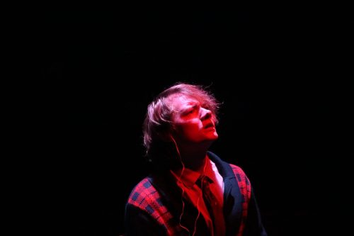 Lamb looking up at the sky during the end of Act 1. He is lit in red lighting
