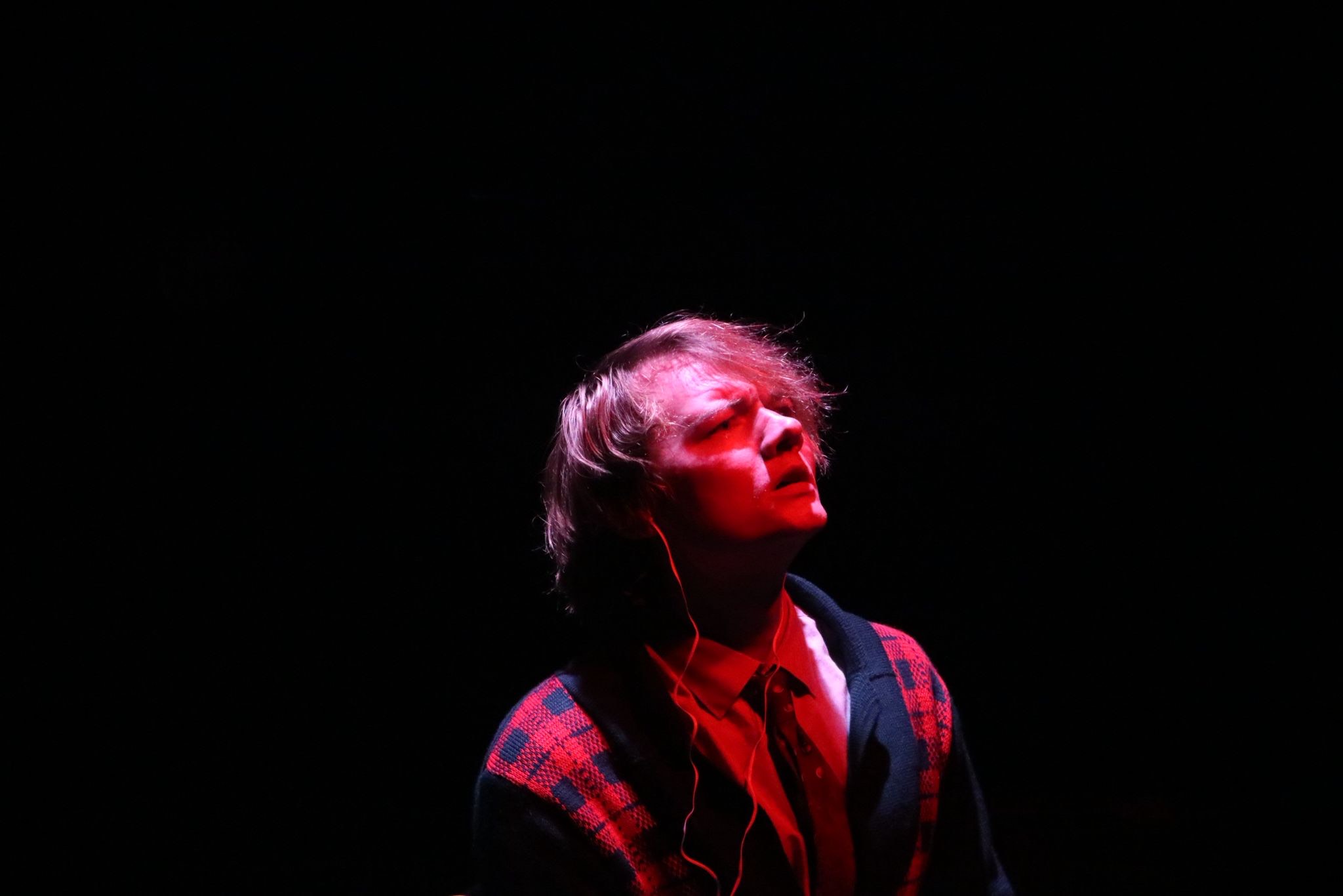 Lamb looking up at the sky during the end of Act 1. He is lit in red lighting
