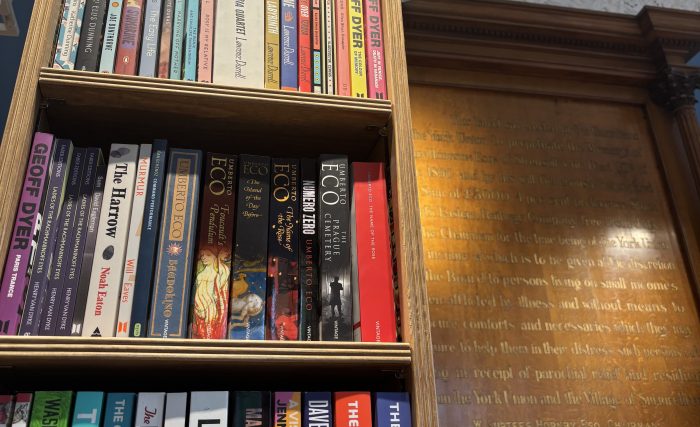 Image of bookshelves next to plaque in store